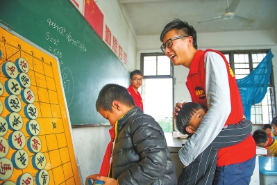 象棋兴趣小组上，一位男孩紧紧抱住一周没见面的大哥哥。