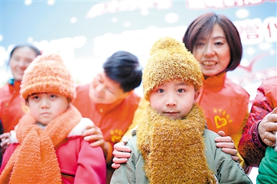 昨日，志愿者为留守儿童代表穿上温暖的冬衣。 本报记者 甘侠义 摄