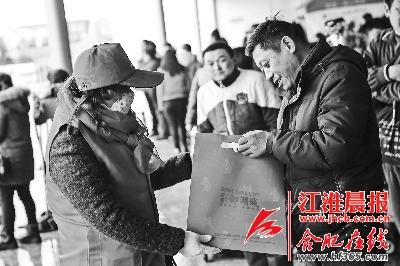 志愿者给乘客派发春节大礼包。
