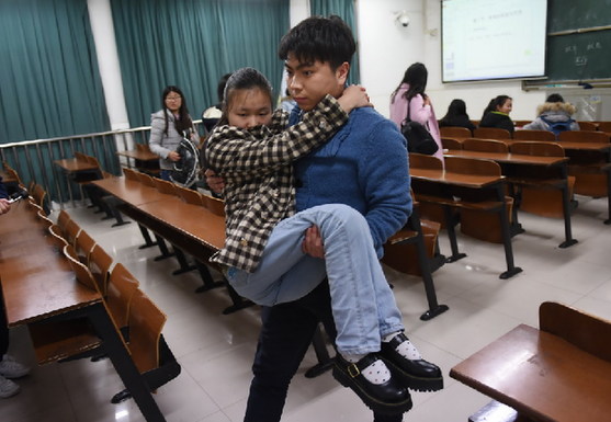 3月9日，下课后陈望的同学胡王建抱着陈望离开教室。新华社记者 李尕 摄