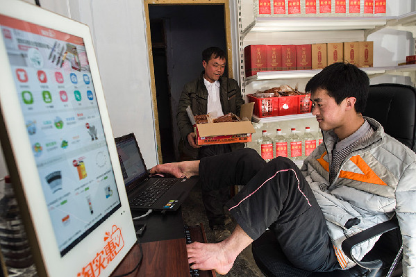 陈兹方（右）在打理他的网店，哥哥陈兹阶（左）帮他搬运货物（3月2日摄）。
