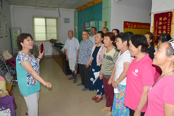 志愿者组织社区居民唱红歌 申华 摄