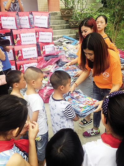 渝中区志愿者为贫困儿童送去学习用品。 市文明办供图
