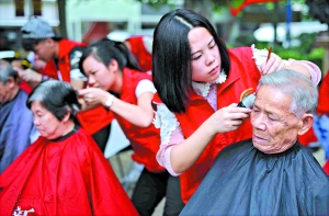 社区志愿者为老人免费剪发。广报记者邱伟荣摄