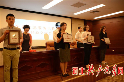 与会领导为志愿者先进典型代表颁发奖牌和证书。记者 黄靖童 摄