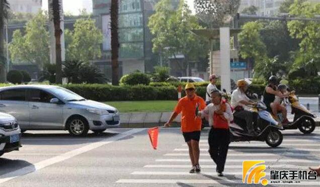 文明交通志愿者护送年迈老人家走过斑马线。图片来源：肇庆手机台