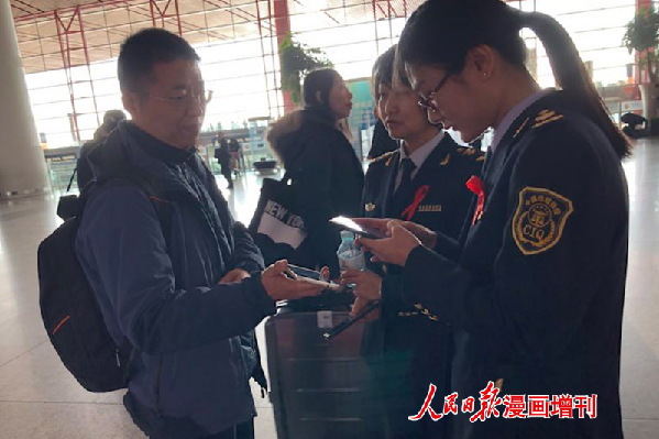 北京出入境检验检疫局青年志愿者为旅客提供网上防艾宣传资料