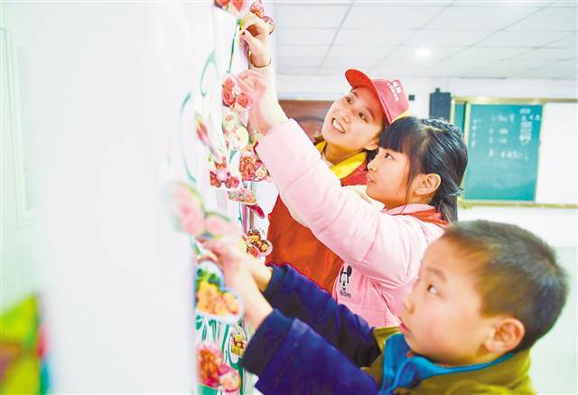 十二月二十六日，国网重庆合川区供电公司青年志愿者和三庙小学的留守儿童一起贴心愿卡